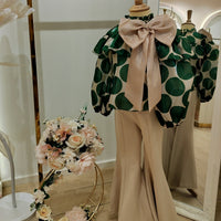 A mannequin wearing a Teen Set outfit, consisting of a top with a modern print and a pair of beige bottoms with an elastic waistband.