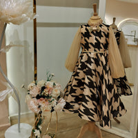 A teenage girl's dress displayed on a mannequin, featuring a flattering A-line silhouette with a fitted bodice and flowy skirt, adorned with delicate lace detailing. The dress is presented in a retail setting with a matching belt, flowers, and other accessories.