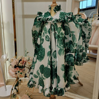 A green floral occasion dress for girls displayed on a mannequin.