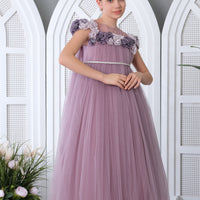 A young girl wearing a lilac colored floral lace dress with a flowy A-line silhouette and a sweetheart neckline.