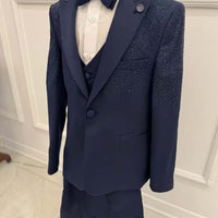 A navy blue boys' suit with a bow tie, consisting of a jacket, waistcoat, and trousers, displayed against a white background.