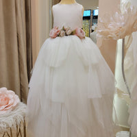 A white, sleeveless, ankle-length dress with gold thread embroidery and tulle layers, displayed on a mannequin.