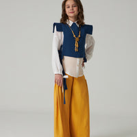 A female model wearing a Teenagers Luxury Pant Set, featuring a white top with blue details and yellow pants.