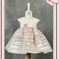 A lovely pink dress with intricate lace detailing, displayed on a mannequin against a grey background with a decorative pink butterfly stamp.